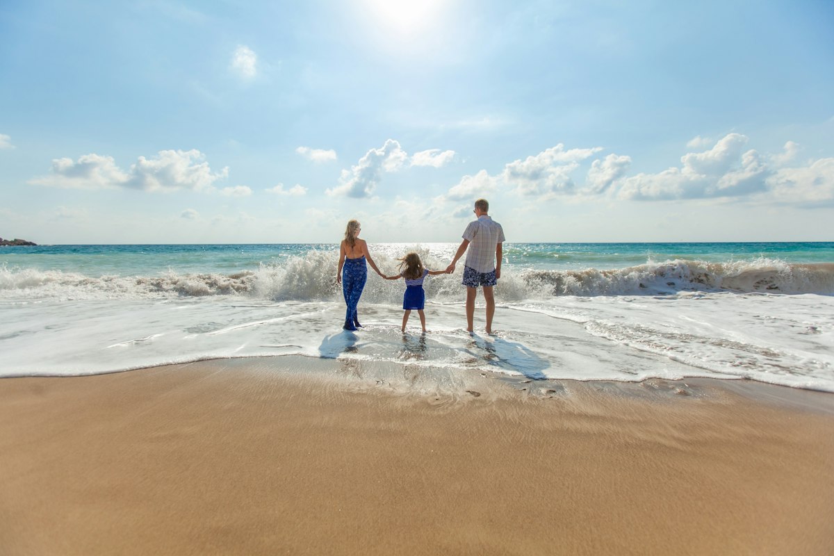 Family walking together along a sunny shoreline